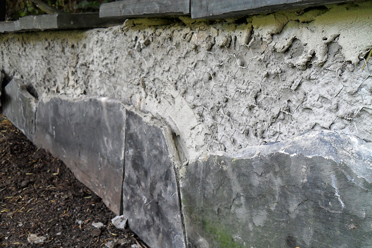 Lange gemauerte Sitzbank - Die Naturstein-Verkleidung mit Polygonalplatten ist stark besch�digt