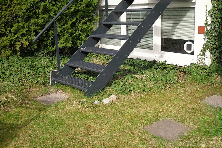 �bergang von einer Treppe in den Garten: Vorher-Situation mit Rasentrittsteinen